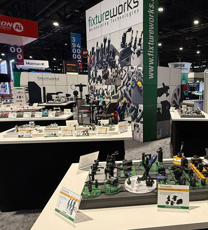 Fixtureworks booth display at a trade show, featuring workholding products on display tables